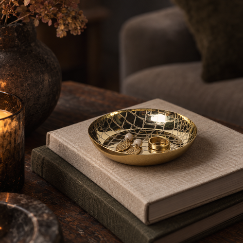 Abigail Ahern Afton brass dish with jewellery on a stack of books