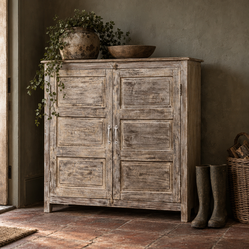 Antique whitewashed solid wood cupboard in a farmhouse hallway