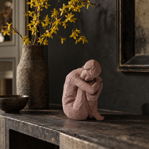 Abigail Ahern Ladera pink seated figure sculpture on a dark console