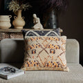 The House look cushion on a greay sofa with a book||