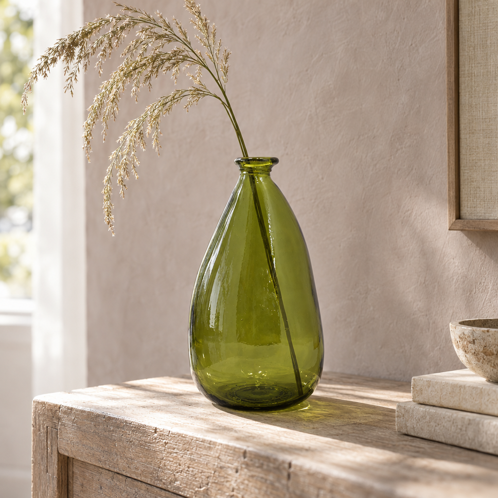 Olive green Simplicity blown recycled glass vase with a stem of grass on a console table