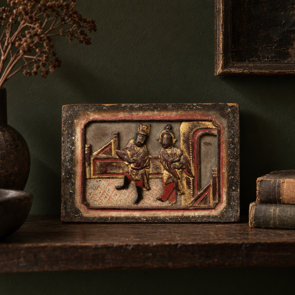 Vintage carved and painted Chinese wooden plaque on a shelf